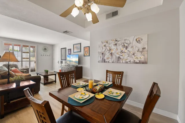 a view of a dining room with furniture a rug and wooden floor