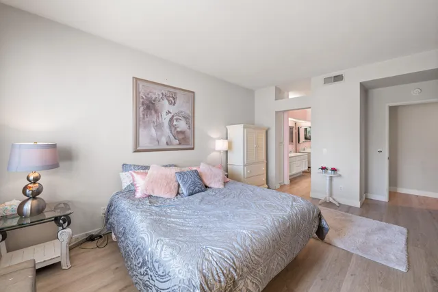 a bedroom with a large bed and a chandelier