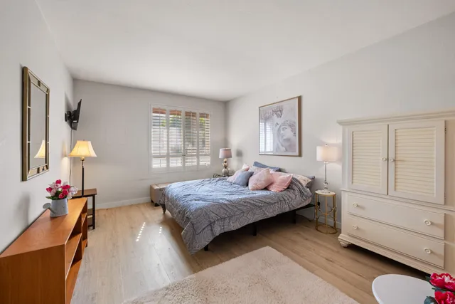 a bedroom with a bed lamp and a window