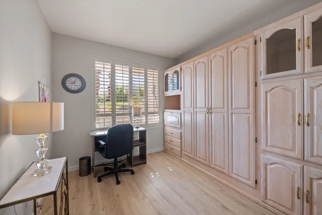 a view of a workspace with furniture and a window