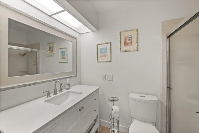 a bathroom with a toilet a sink and mirror