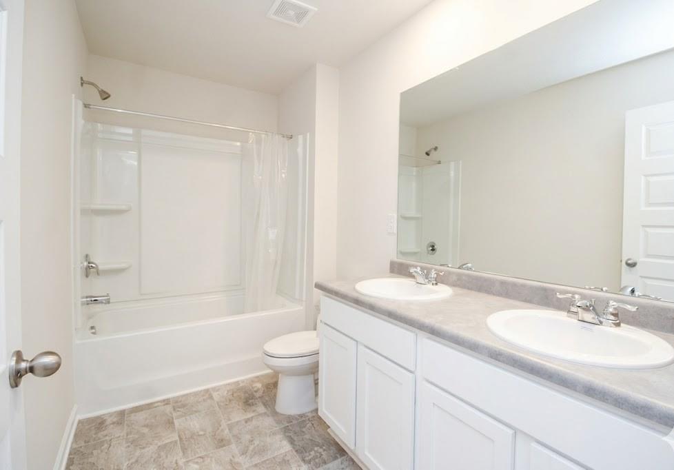 2264 Pelham Pass Dacula, GA 30019 - Photo 24 of 41 a bathroom with a granite countertop sink a toilet and shower