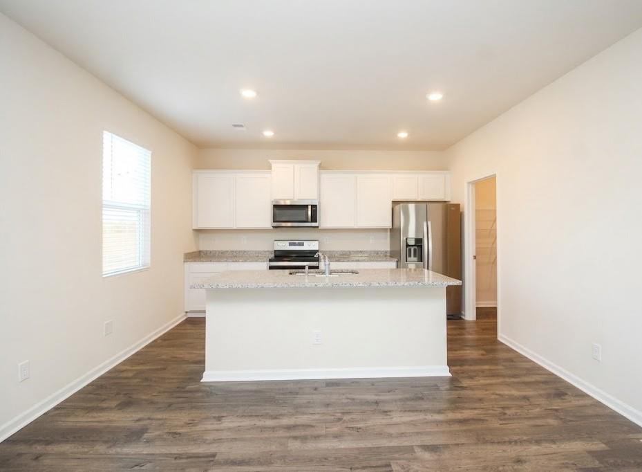 2264 Pelham Pass Dacula, GA 30019 - Photo 10 of 41 a kitchen with kitchen island stainless steel appliances a sink and a refrigerator