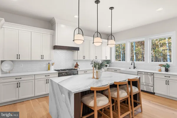 a kitchen with stainless steel appliances a stove a sink island and a refrigerator