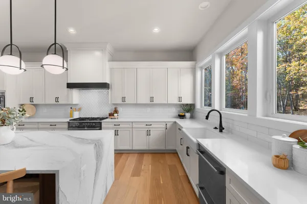 a kitchen with stainless steel appliances kitchen island a sink a refrigerator and cabinets