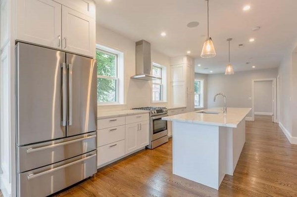 a kitchen with kitchen island white cabinets and stainless steel appliances