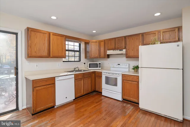 a kitchen with stainless steel appliances granite countertop wooden cabinets a sink and a stove