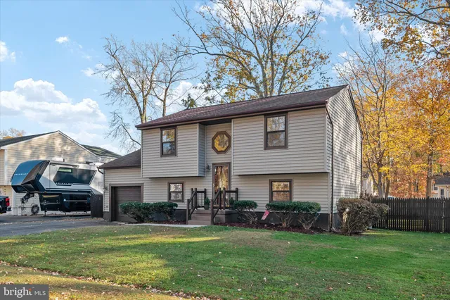 a front view of a house with a garden and trees