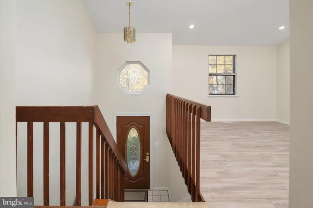 a view of a hallway with wooden floor and windows