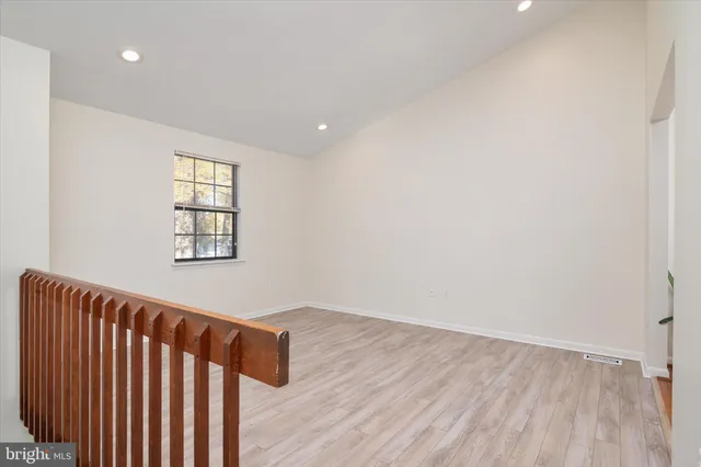 a view of a hallway with dining room and wooden floor