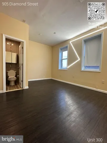 a view of an empty room with wooden floor and a cabinet