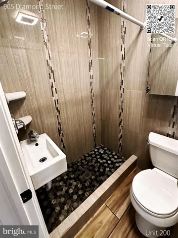 a bathroom with a sink a toilet a shower and a mirror