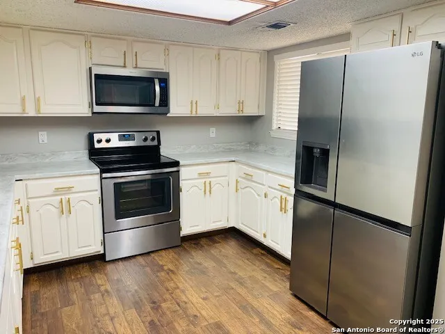 a kitchen with white cabinets and stainless steel appliances
