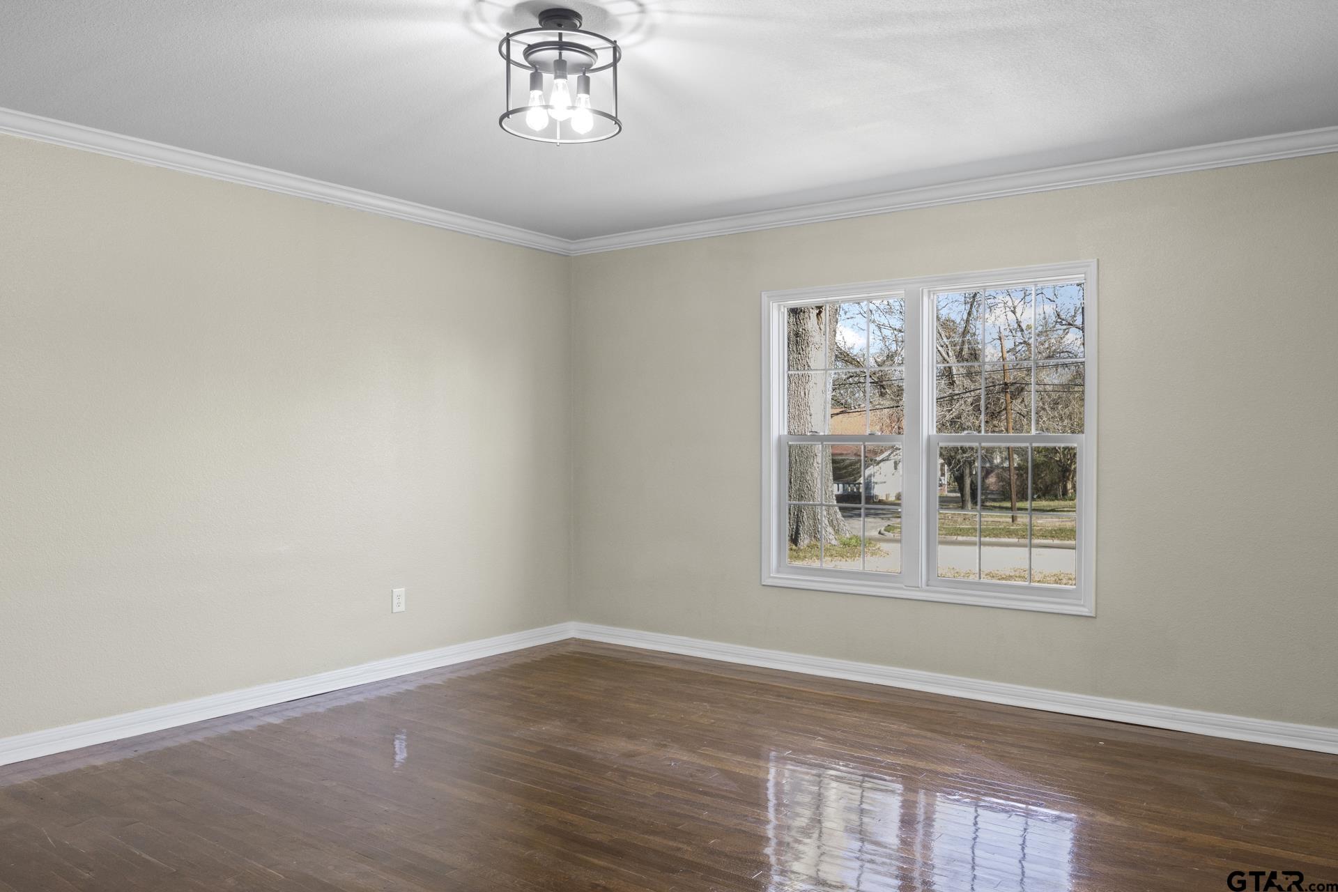 306 Quitman Street Pittsburg, TX 75686 - Photo 11 of 31 a view of an empty room with a window and wooden floor