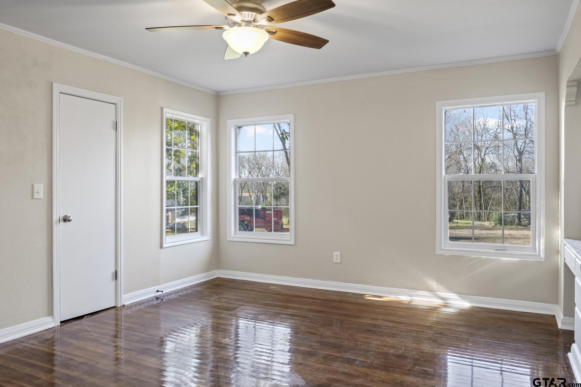 306 Quitman Street Pittsburg, TX 75686 - Photo 12 of 31 a view of an empty room with wooden floor and a window
