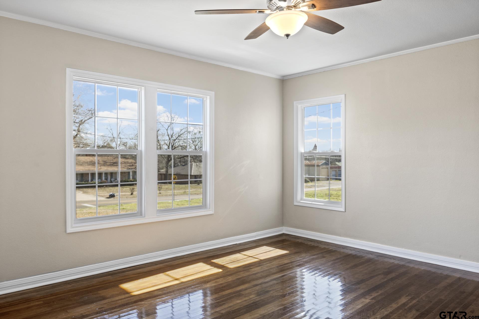 306 Quitman Street Pittsburg, TX 75686 - Photo 14 of 31 a view of an empty room with wooden floor and a window