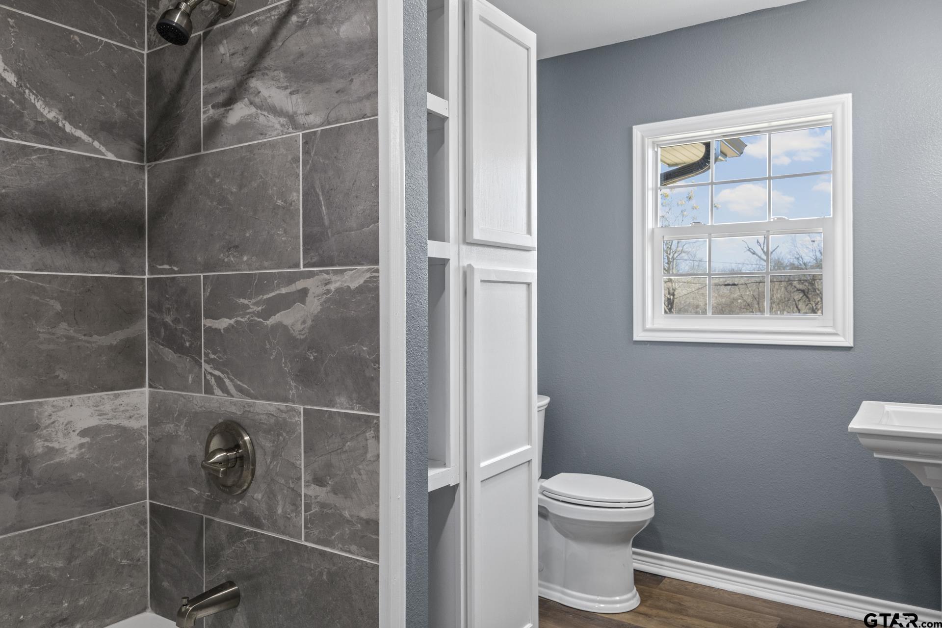 306 Quitman Street Pittsburg, TX 75686 - Photo 15 of 31 a bathroom with a toilet and a shower