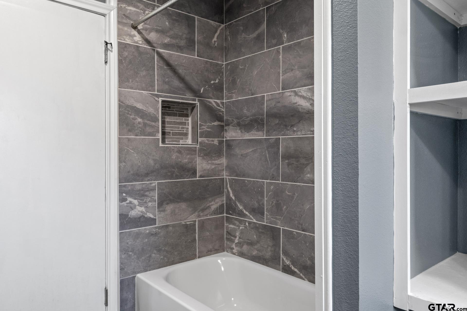 306 Quitman Street Pittsburg, TX 75686 - Photo 16 of 31 a bath tub sitting next to a white sink