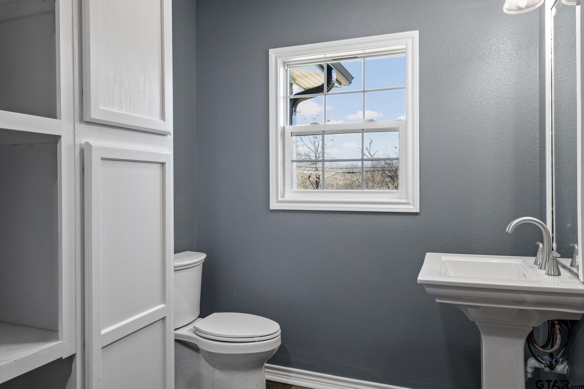 306 Quitman Street Pittsburg, TX 75686 - Photo 17 of 31 a bathroom with a sink a toilet and a window