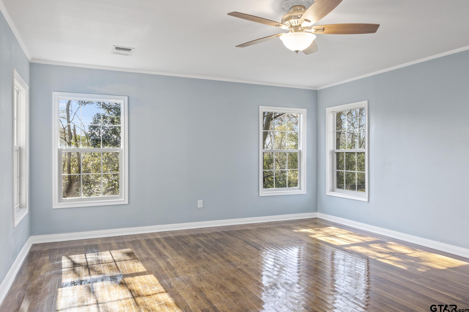 306 Quitman Street Pittsburg, TX 75686 - Photo 18 of 31 a view of an empty room with wooden floor and a window