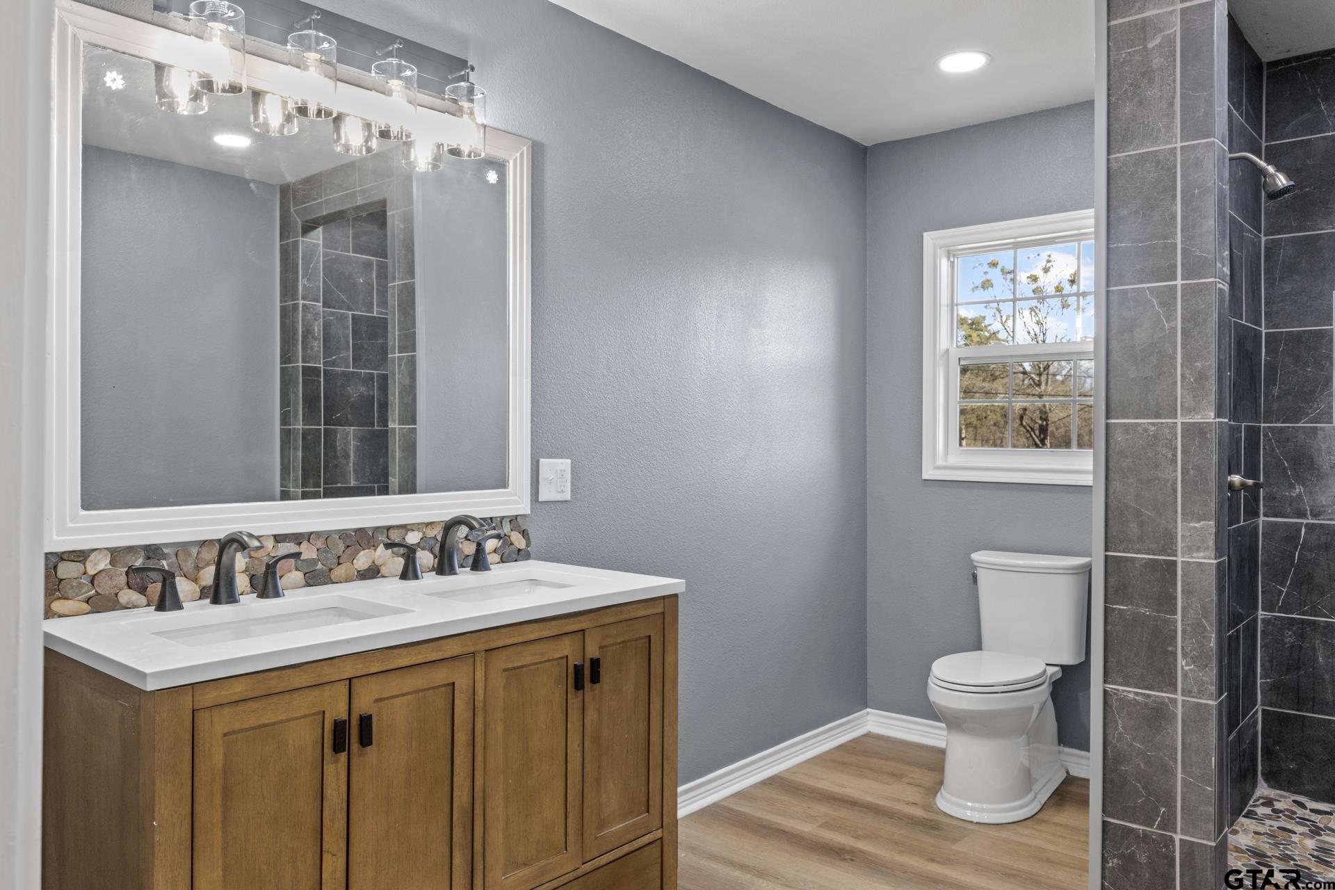 306 Quitman Street Pittsburg, TX 75686 - Photo 22 of 31 a bathroom with a sink a toilet and shower