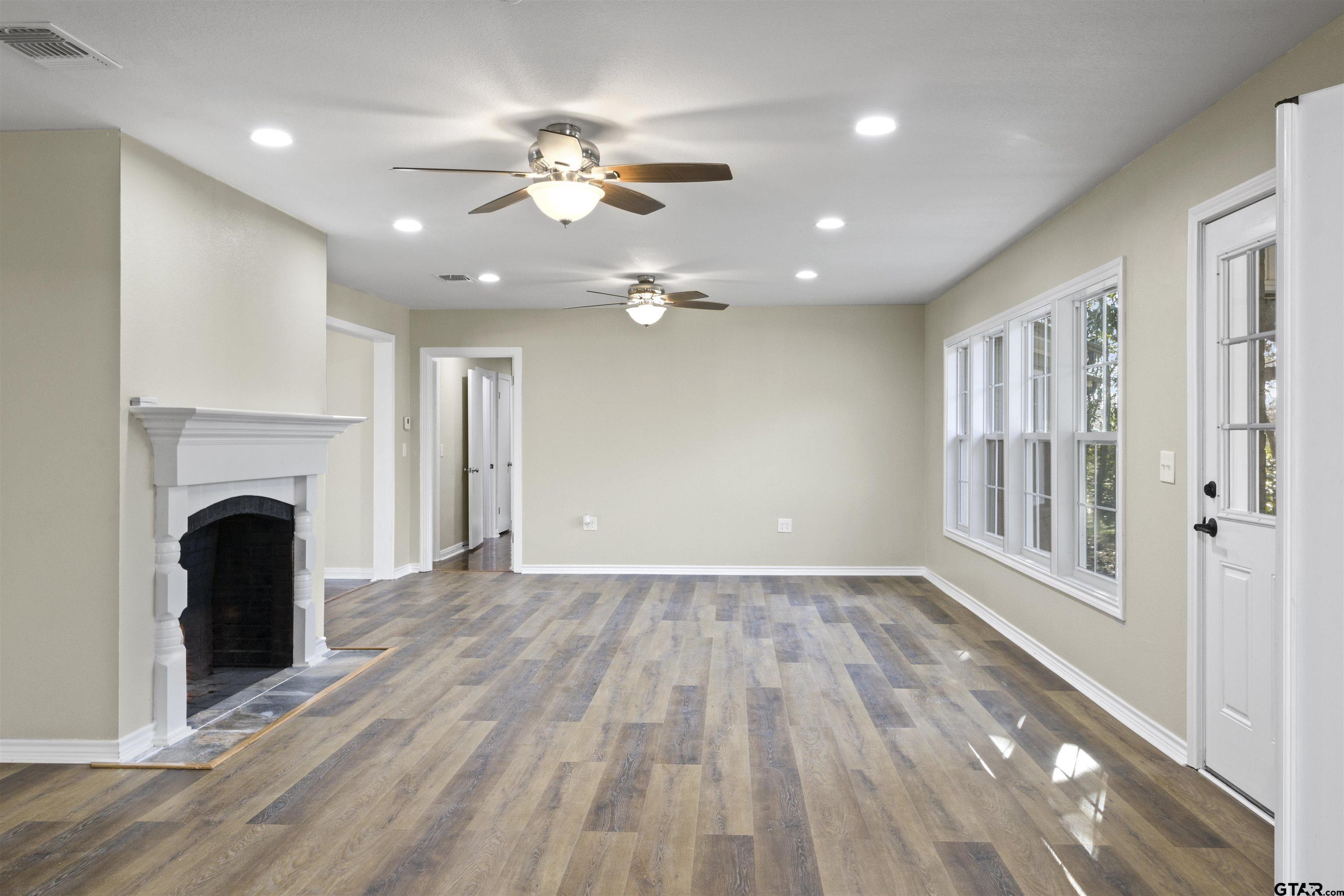 306 Quitman Street Pittsburg, TX 75686 - Photo 23 of 31 a view of an empty room with wooden floor and fireplace
