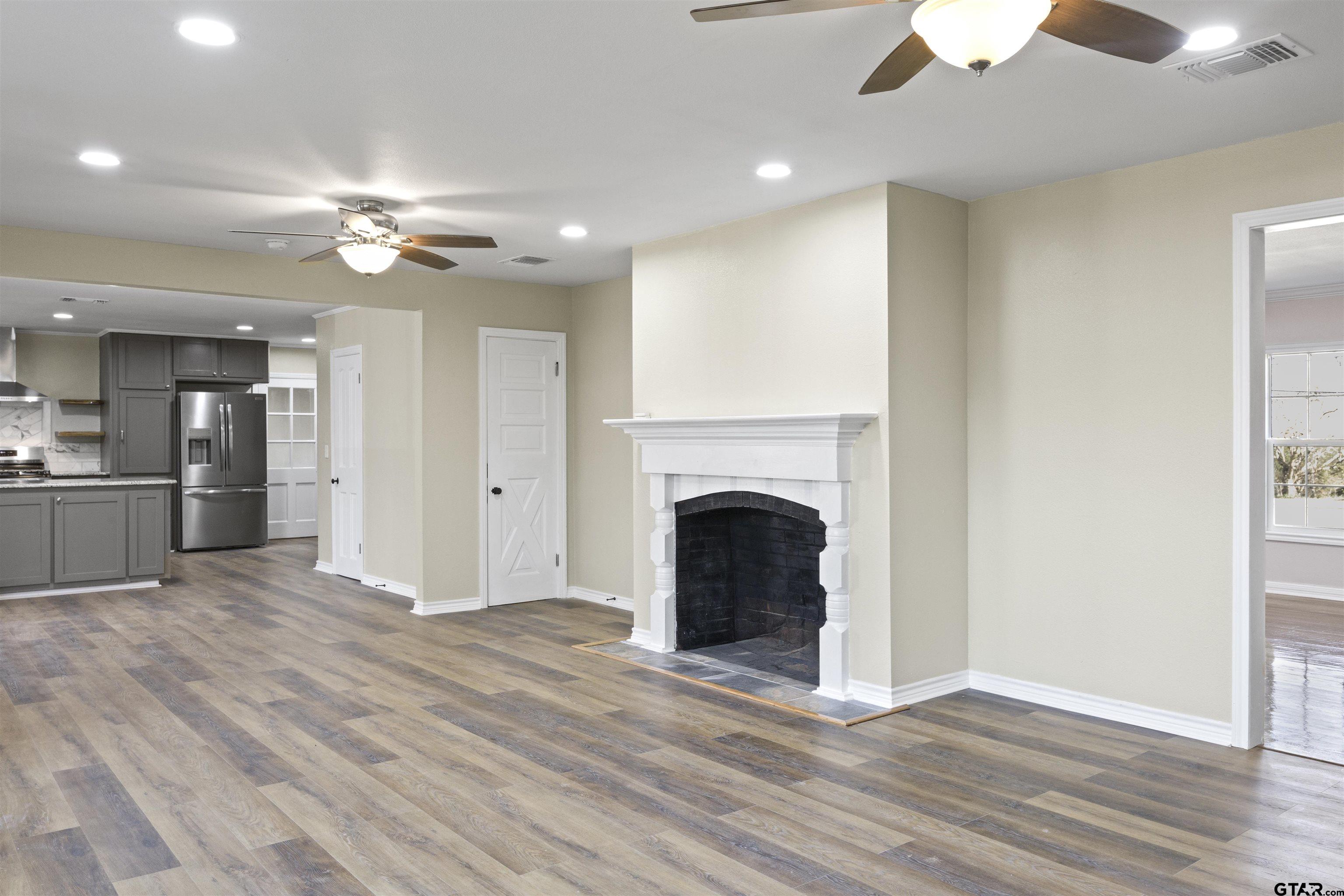 306 Quitman Street Pittsburg, TX 75686 - Photo 26 of 31 a view of a livingroom with a fireplace a ceiling fan and closet area
