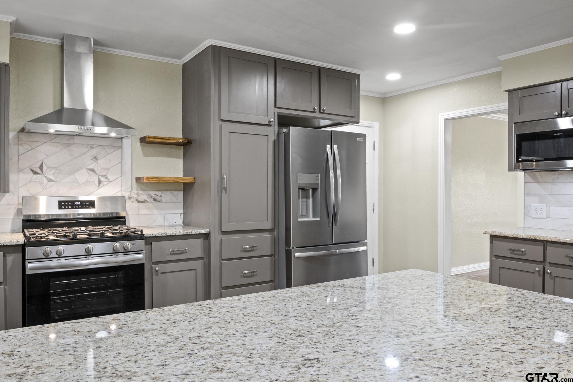 306 Quitman Street Pittsburg, TX 75686 - Photo 5 of 31 a kitchen with a refrigerator and a stove top oven