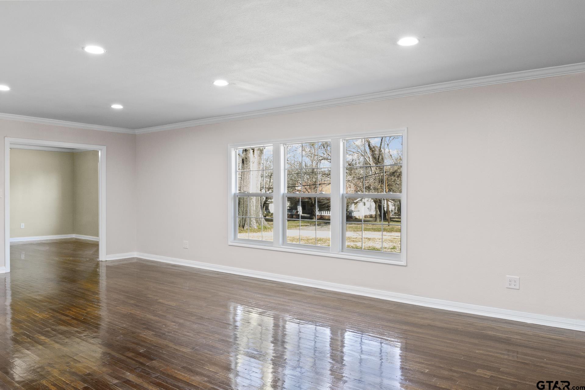 306 Quitman Street Pittsburg, TX 75686 - Photo 10 of 31 an empty room with wooden floor and a window
