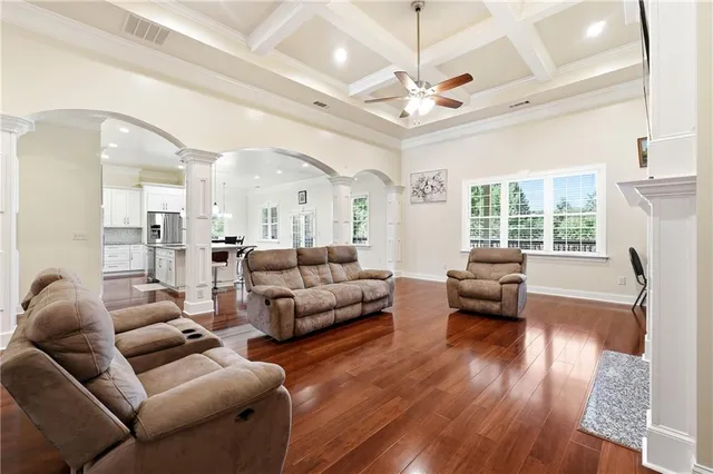 a kitchen with stainless steel appliances refrigerator wooden floor and chairs