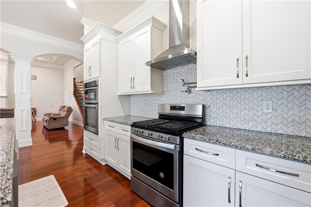 100 Marshas Vineyard Hampton, GA 30228 - Photo 19 of 71 a kitchen with stainless steel appliances granite countertop a stove and a white cabinets