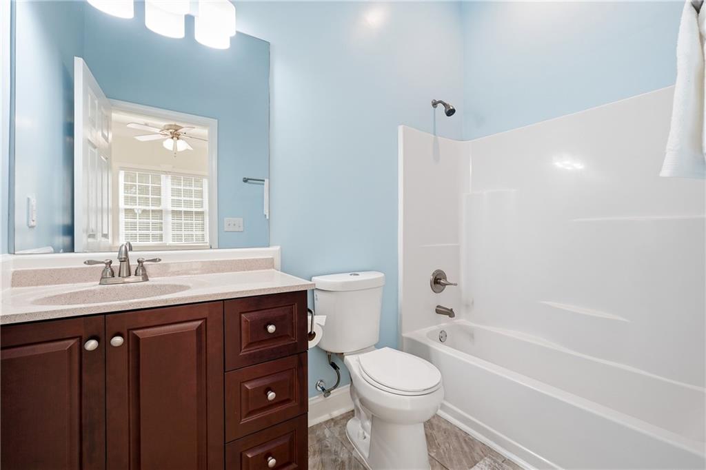 100 Marshas Vineyard Hampton, GA 30228 - Photo 34 of 71 a bathroom with a granite countertop sink toilet a large mirror a bathtub and shower