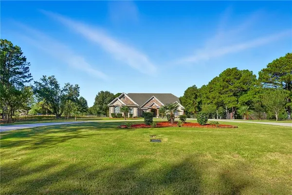 a front view of a house with a garden and plants