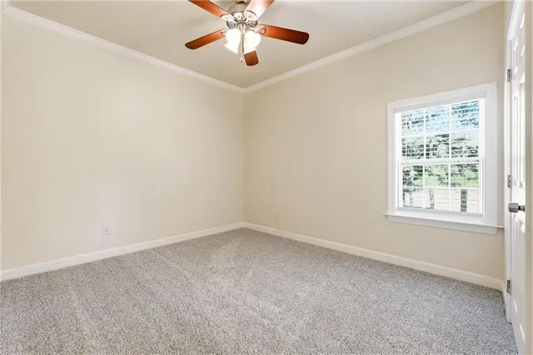 a large white kitchen with granite countertop a stove a sink and white cabinets with wooden floor