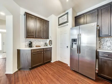 a kitchen with stainless steel appliances granite countertop a refrigerator and a stove top oven