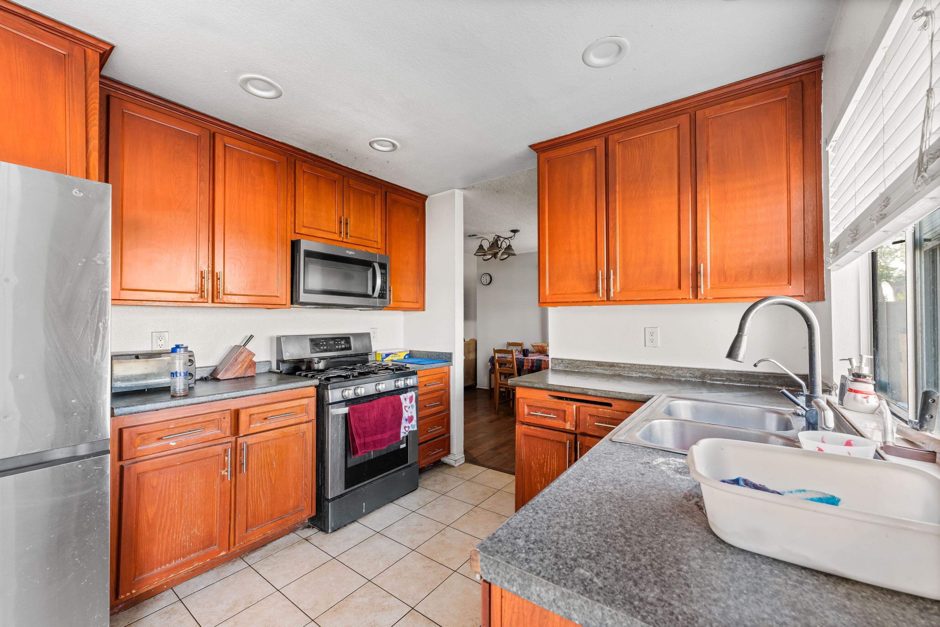 37826 Cardiff Street Palmdale, CA 93550 - Photo 9 of 22 a kitchen with stainless steel appliances granite countertop sink stove top oven and cabinets