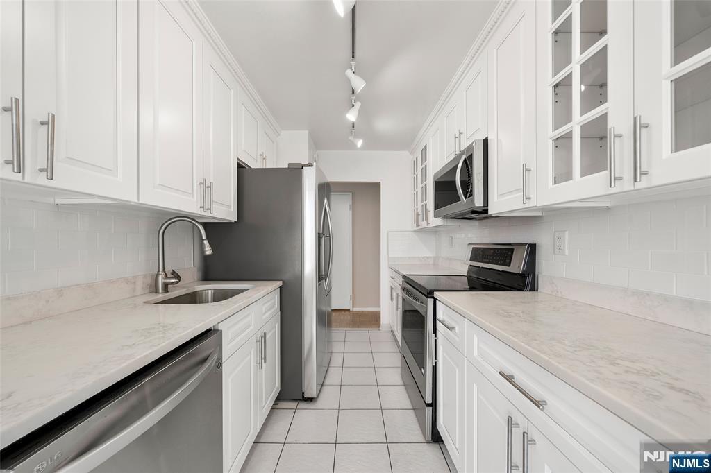 200 Winston Drive, Unit 508 Cliffside Park, NJ 07010 - Photo 9 of 25 a kitchen with stainless steel appliances granite countertop a sink stove and refrigerator