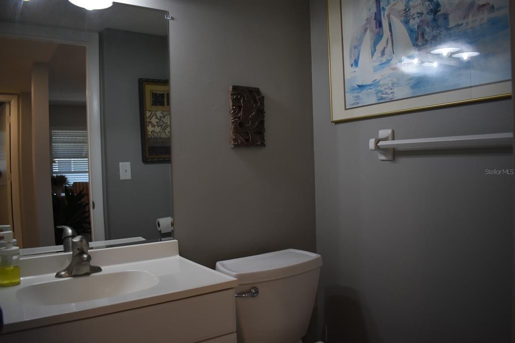 250 Rosery Road Northwest, Unit 264 Largo, FL 33770 - Photo 11 of 18 a bathroom with a toilet a sink and mirror