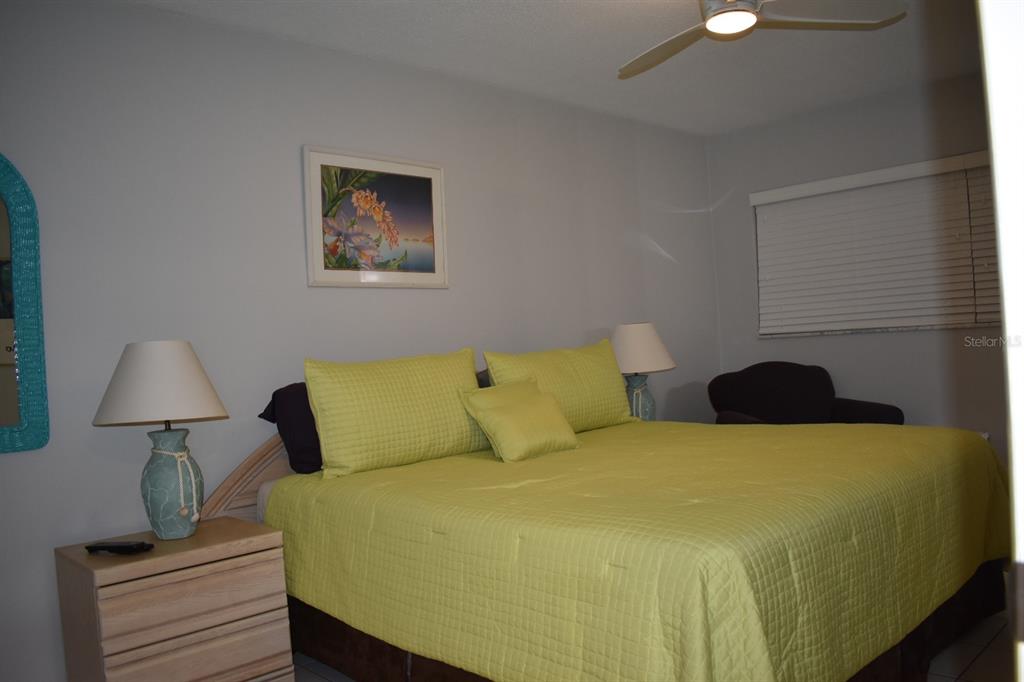 250 Rosery Road Northwest, Unit 264 Largo, FL 33770 - Photo 12 of 18 a bedroom with a bed and a lamp on table