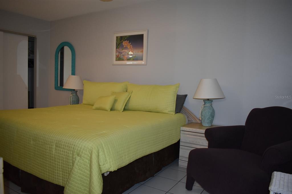 250 Rosery Road Northwest, Unit 264 Largo, FL 33770 - Photo 13 of 18 a bedroom with a bed and a lamp on dresser