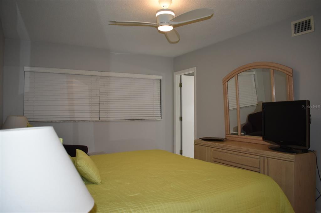 250 Rosery Road Northwest, Unit 264 Largo, FL 33770 - Photo 14 of 18 a bedroom with a bed and a flat screen tv