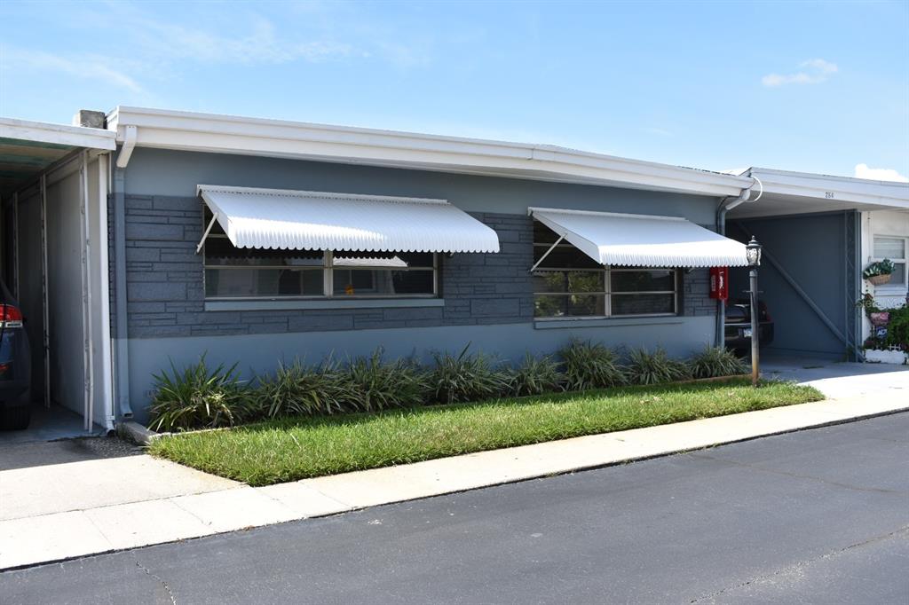 250 Rosery Road Northwest, Unit 264 Largo, FL 33770 - Photo 2 of 18 a front view of a house with a yard and garage