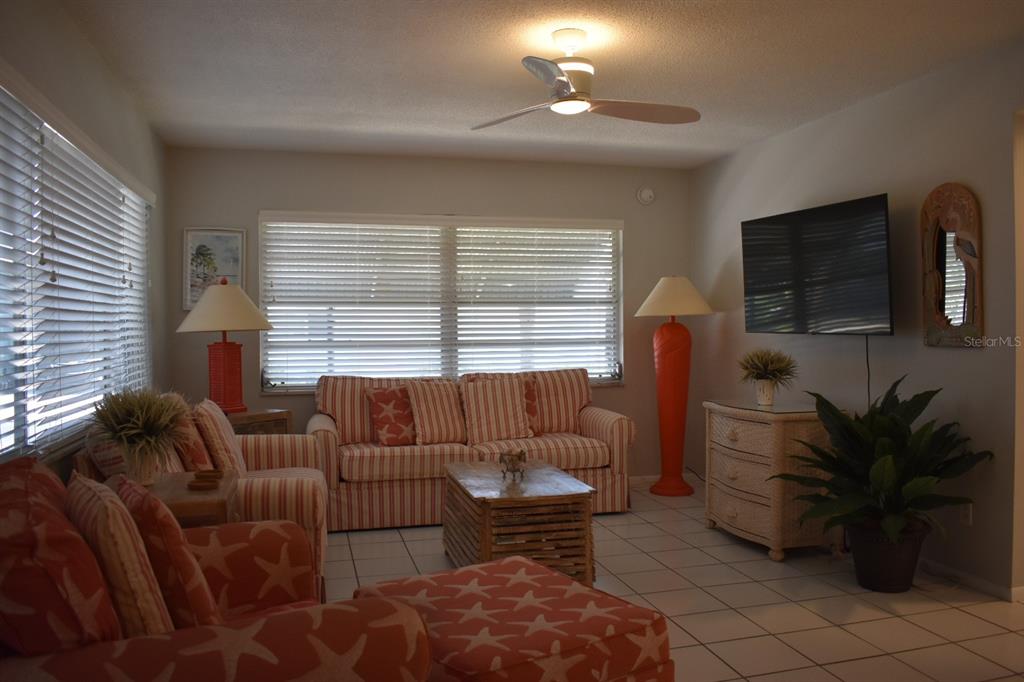 250 Rosery Road Northwest, Unit 264 Largo, FL 33770 - Photo 4 of 18 a living room with furniture a flat screen tv and a window
