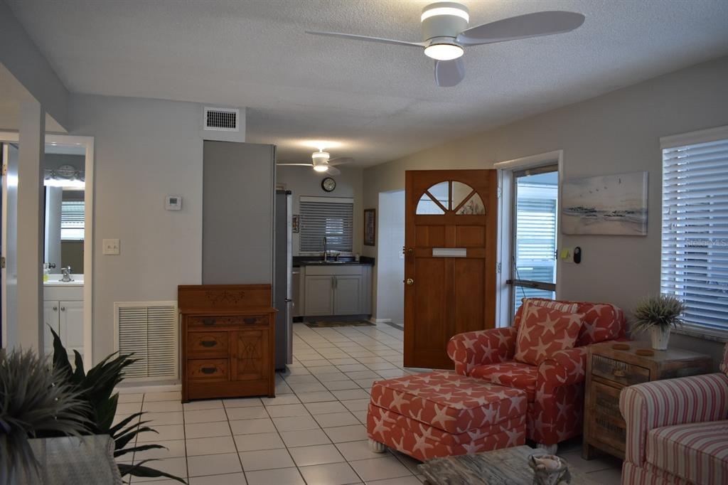 250 Rosery Road Northwest, Unit 264 Largo, FL 33770 - Photo 5 of 18 a living room with furniture and a chandelier