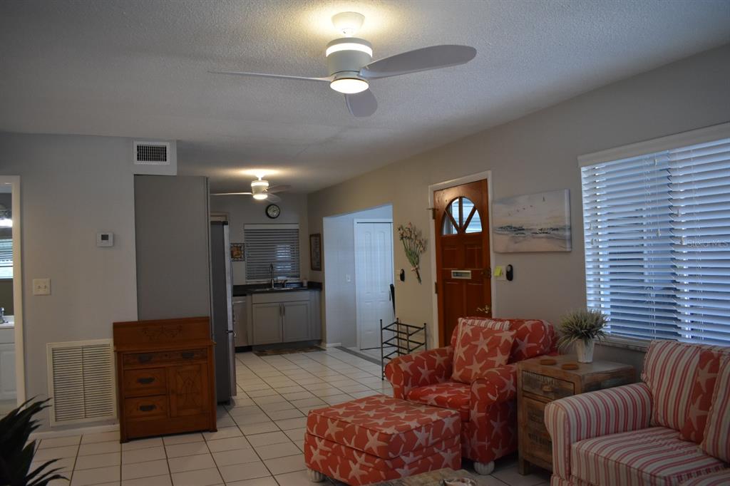250 Rosery Road Northwest, Unit 264 Largo, FL 33770 - Photo 6 of 18 a living room with furniture and kitchen chandelier