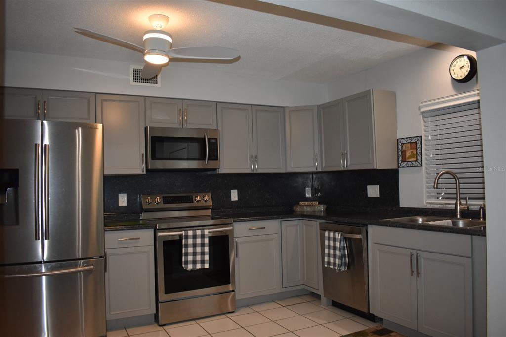 250 Rosery Road Northwest, Unit 264 Largo, FL 33770 - Photo 7 of 18 a kitchen with a sink stainless steel appliances and cabinets