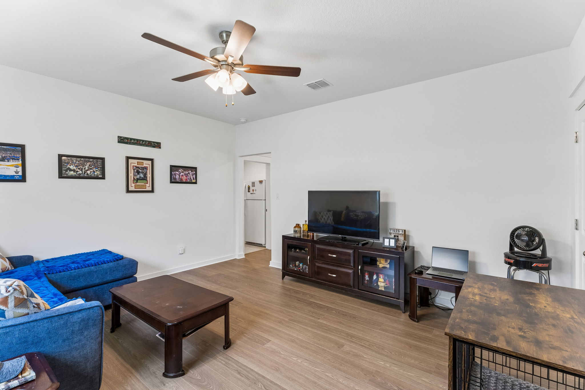 13509 Barn Chime Street Elgin, TX 78621 - Photo 26 of 40 Spacious living area featuring light wood-finish flooring, a contemporary ceiling fan with integrated lighting, and crisp white walls