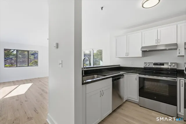 a kitchen with stainless steel appliances granite countertop a stove and a sink