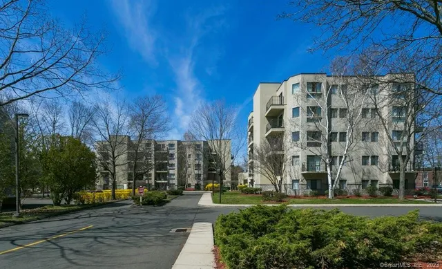 a front view of multi story residential apartment building with garage and plants