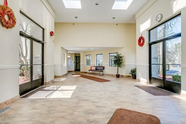 a view of a hall way with furniture and floor to ceiling window